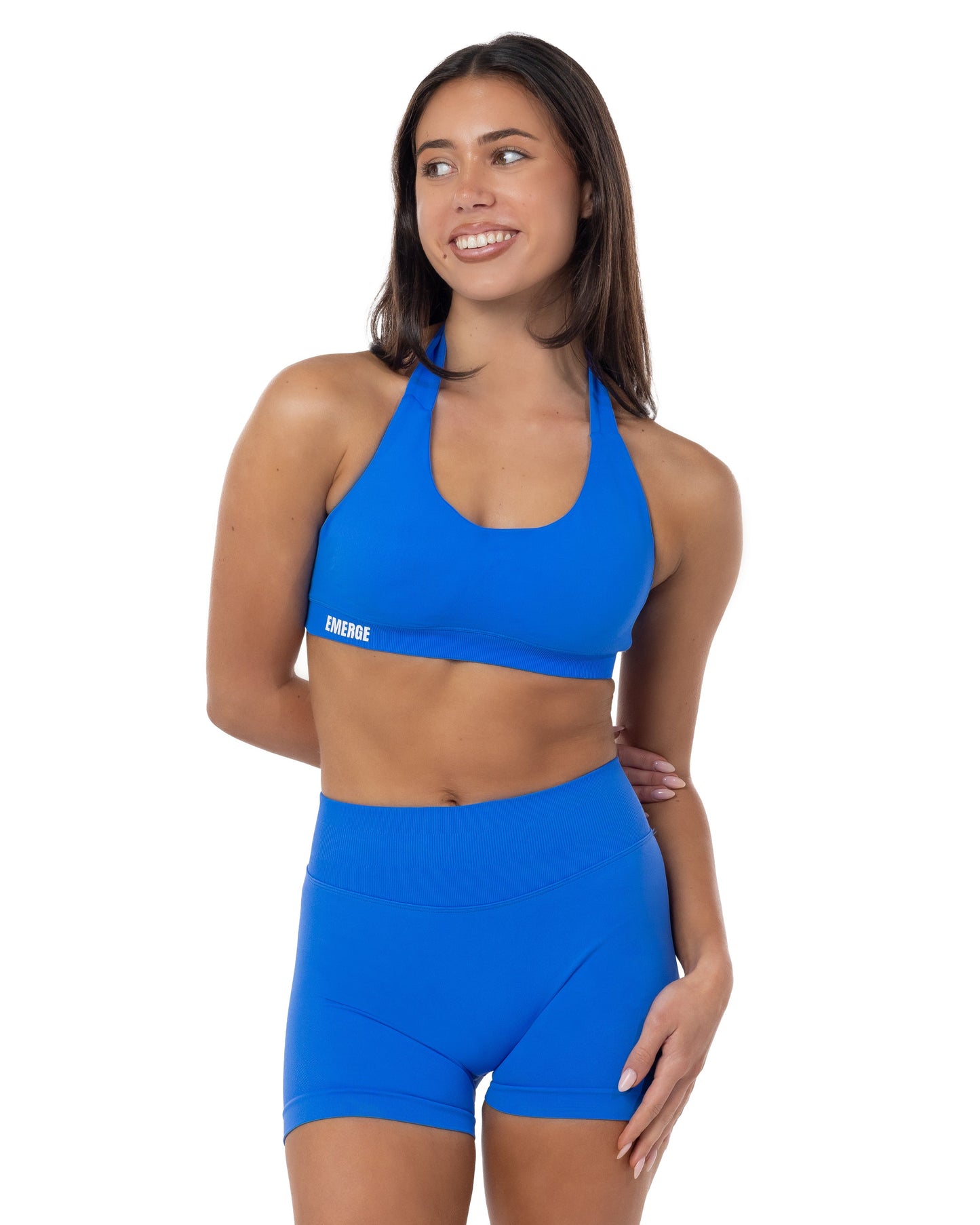 Woman wearing a blue sports bra and shorts set on a white background
