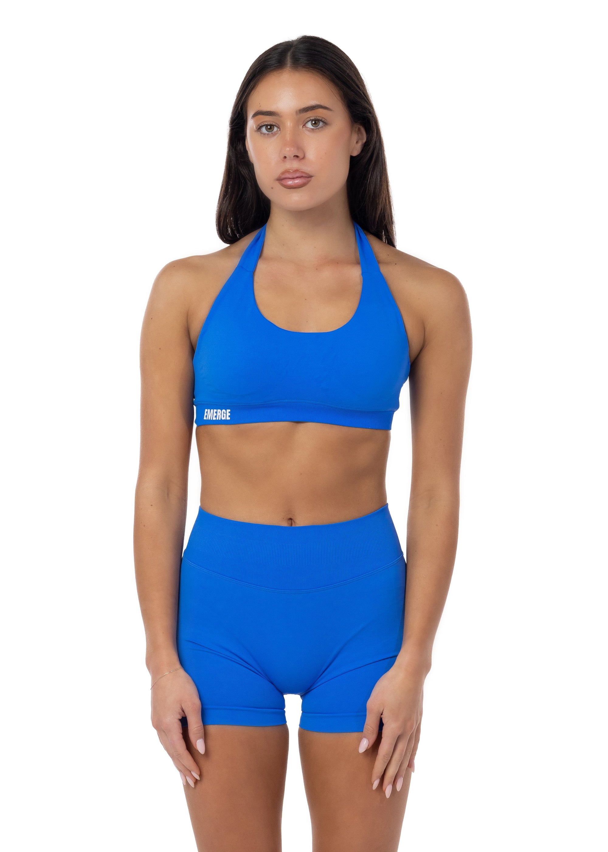 Woman wearing a blue sports bra and shorts set on a white background