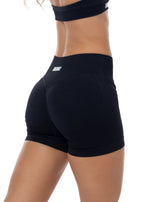 Black athletic shorts worn by a person on a white background