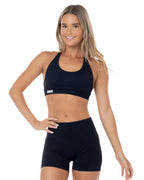 Woman wearing a black sports bra and shorts set on a white background