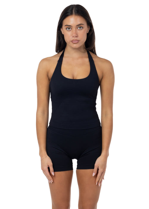 Woman wearing a black halter top and black shorts on a white background