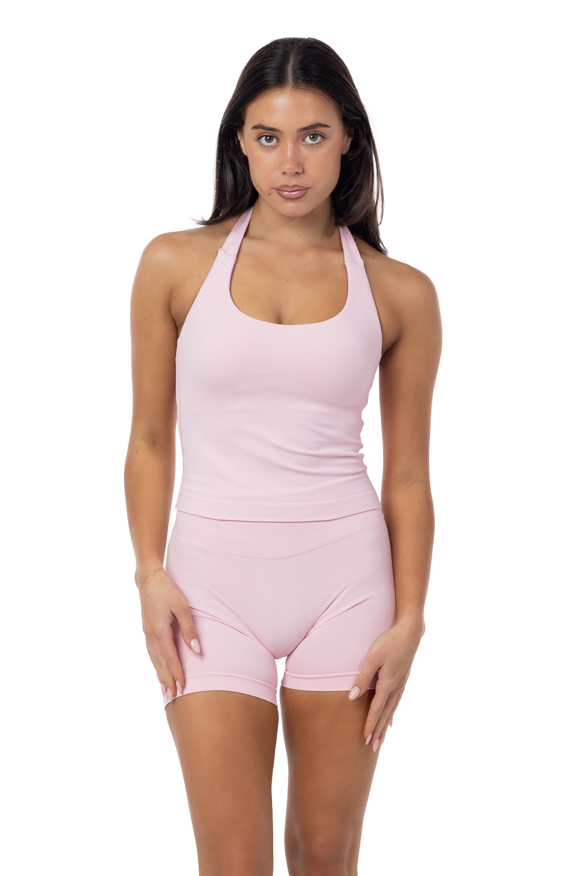 Woman wearing a pink athletic outfit on a white background