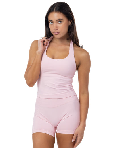Woman wearing a pink sleeveless top and shorts set on a white background